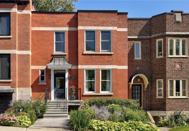 Red brick townhouse with lush green landscaping